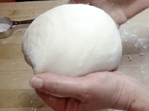 Hands shaping bread dough