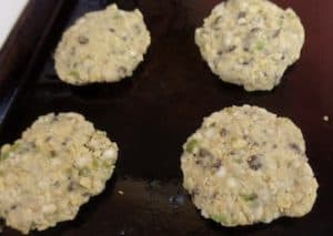 Four garbanzo bean burgers on a baking pan