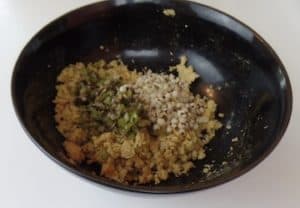 A bowl with mashed garbanzo beans, cooked minced vegetables and cooked barley